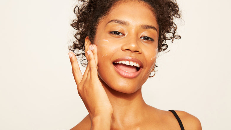 Woman applying retinoid cream to face