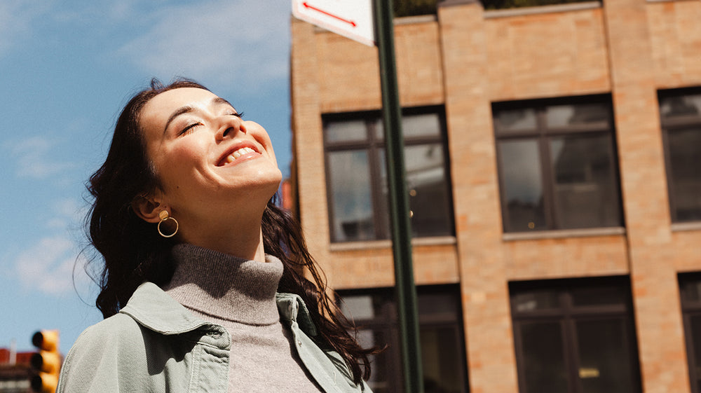 Woman smiling with eyes closed in a city