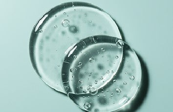 Clear gel-like substance with bubbles on a light blue background
